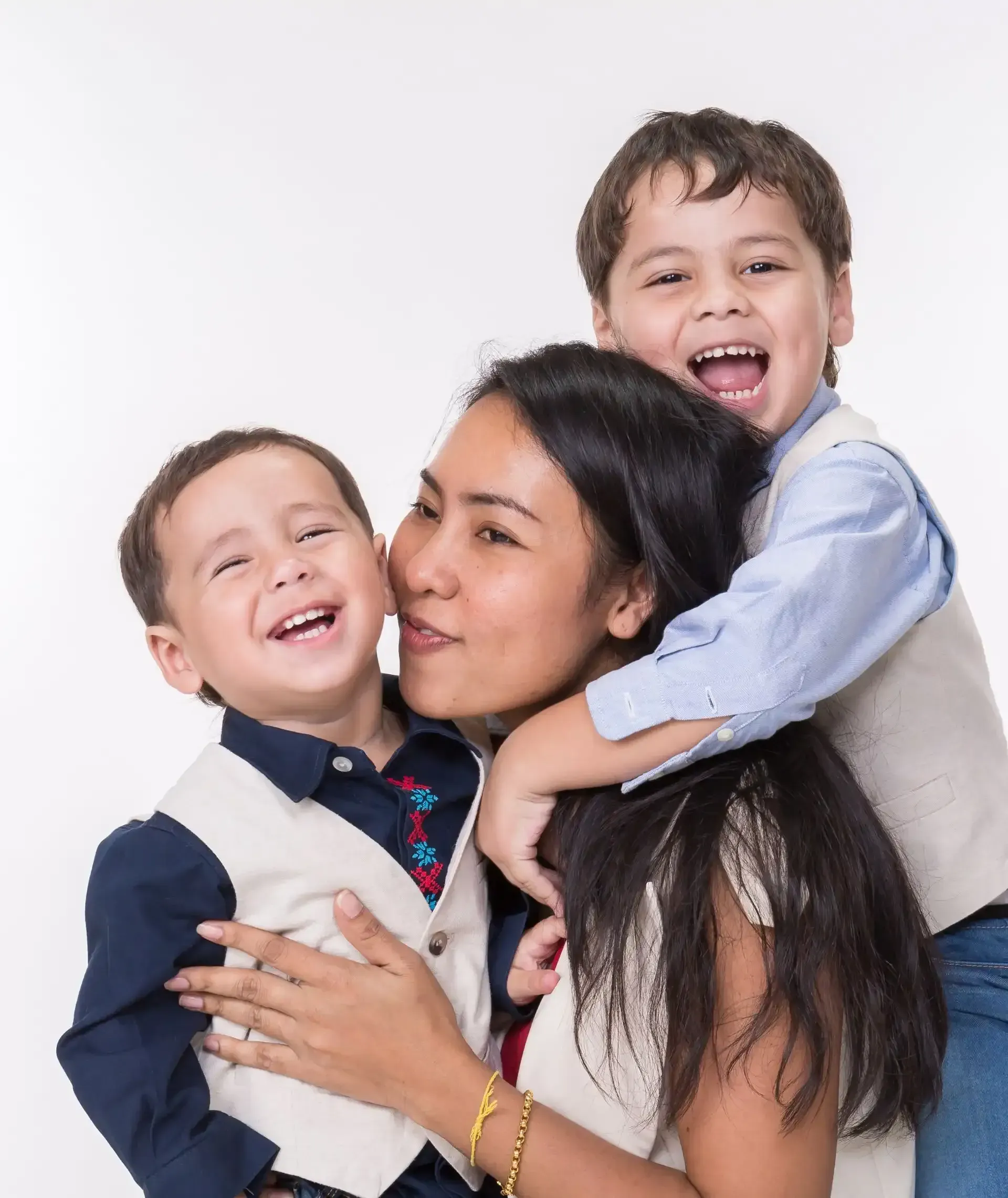 A woman is holding two young boys in her arms