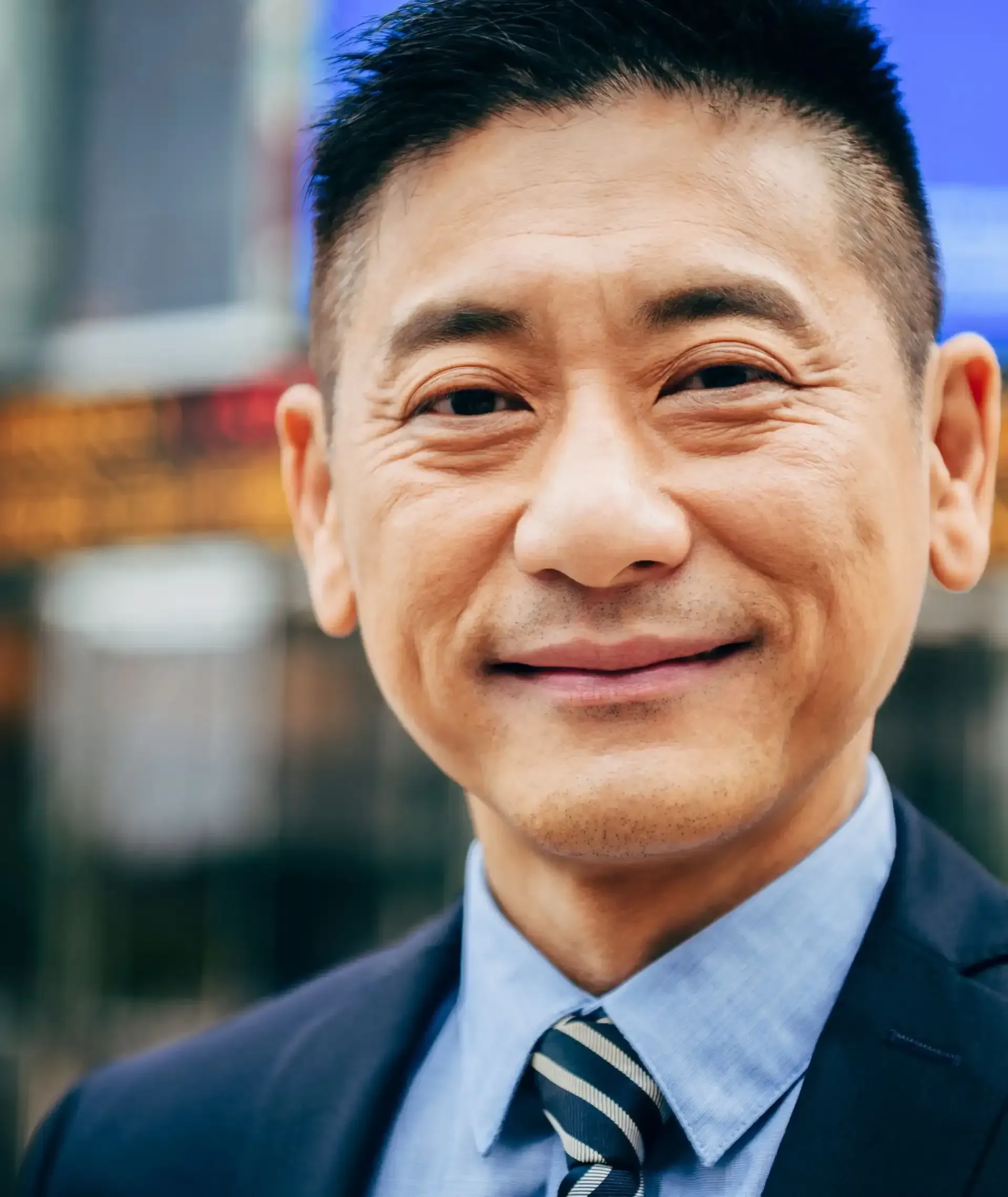 A man in a suit and tie is smiling for the camera