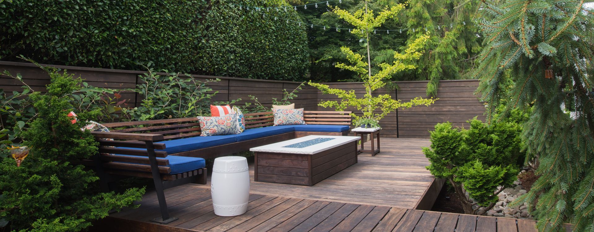 A wooden deck with a fire pit and a couch.