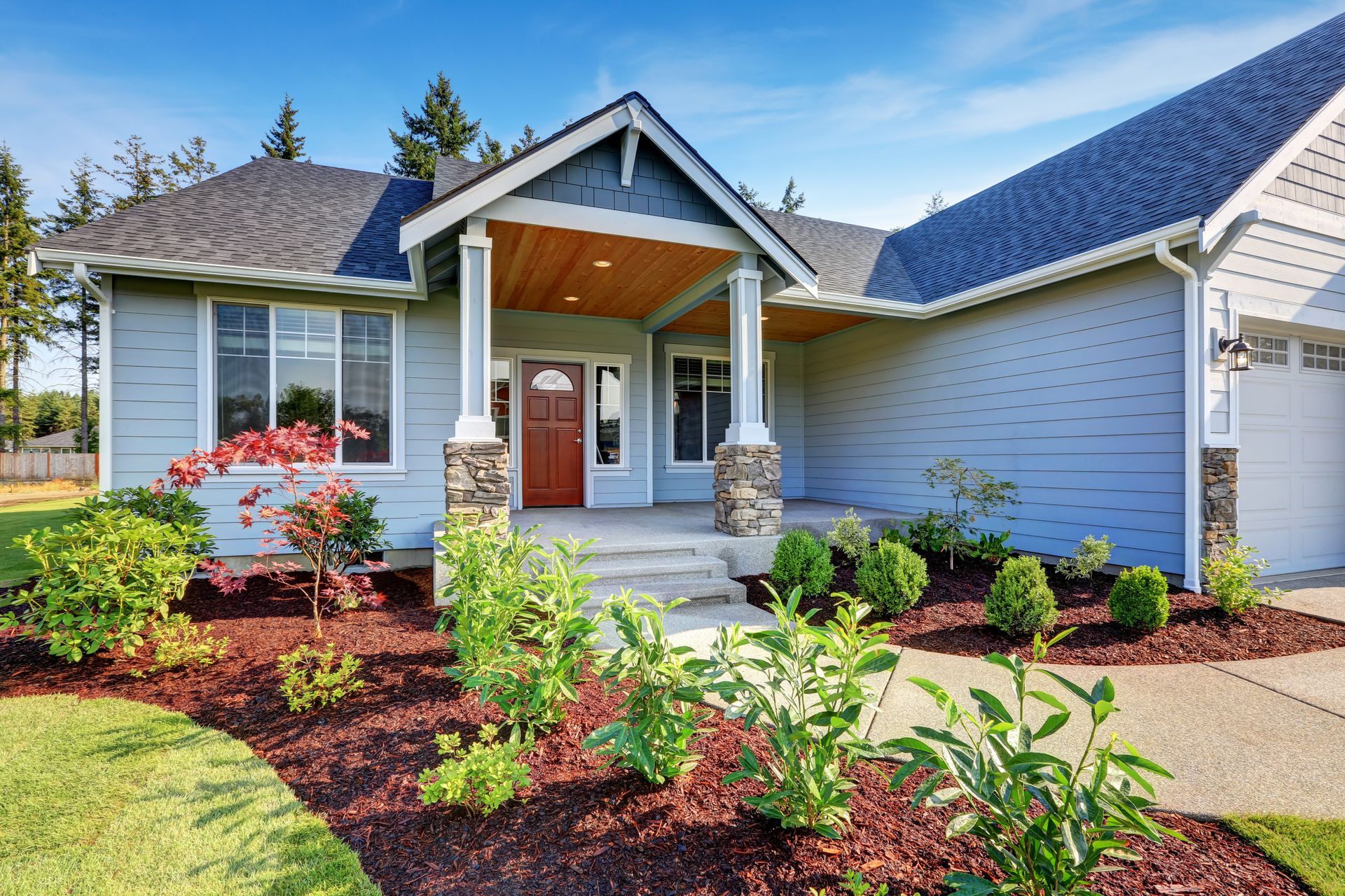 A blue house with a red door and a walkway in front of it.