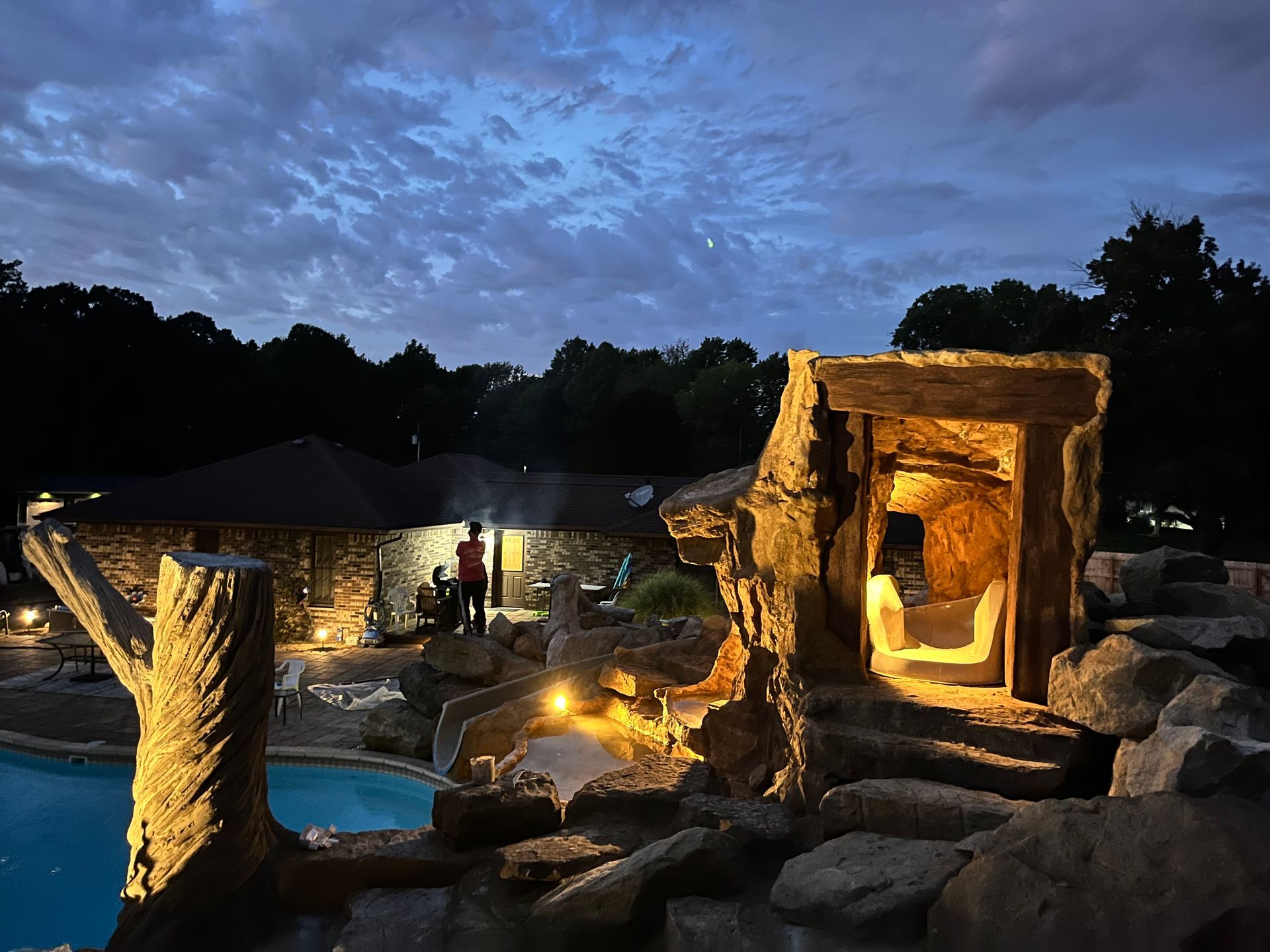  Elite Outdoor Living Solutions is installing a pool with a rock waterfall and nighttime lighting in Yukon, OK.