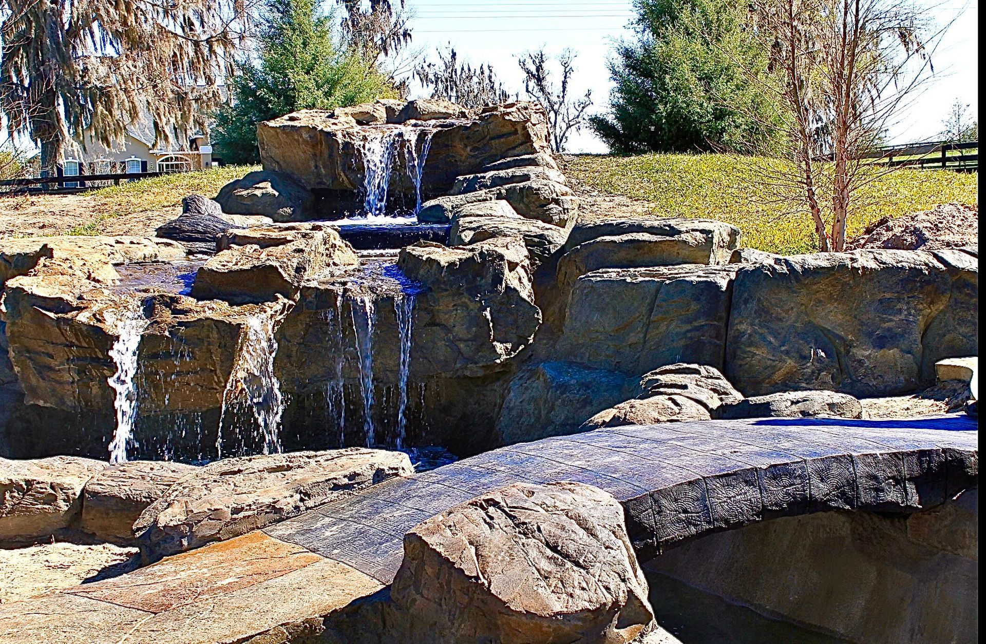 A waterfall surrounded by rocks and trees in a park