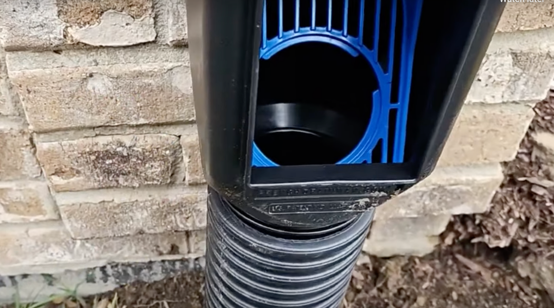 Close-up of a gutter downspout adapter connecting to a drainage pipe, installed by Elite in Oklahoma City, OK.