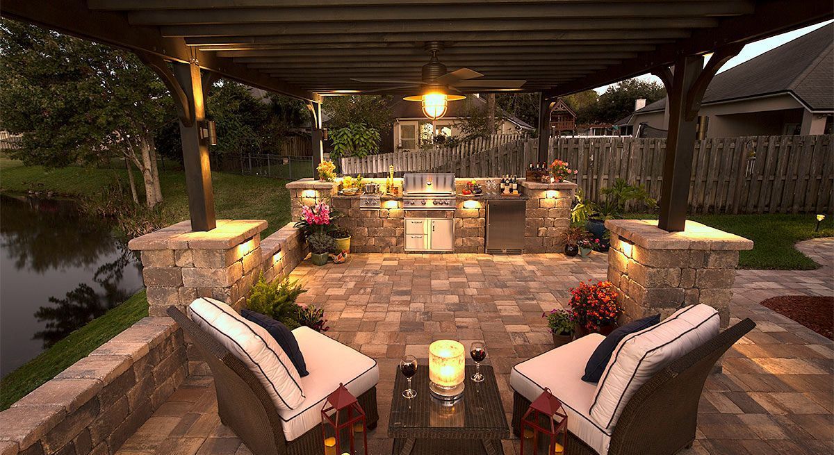 A patio with chairs and a table under a pergola.