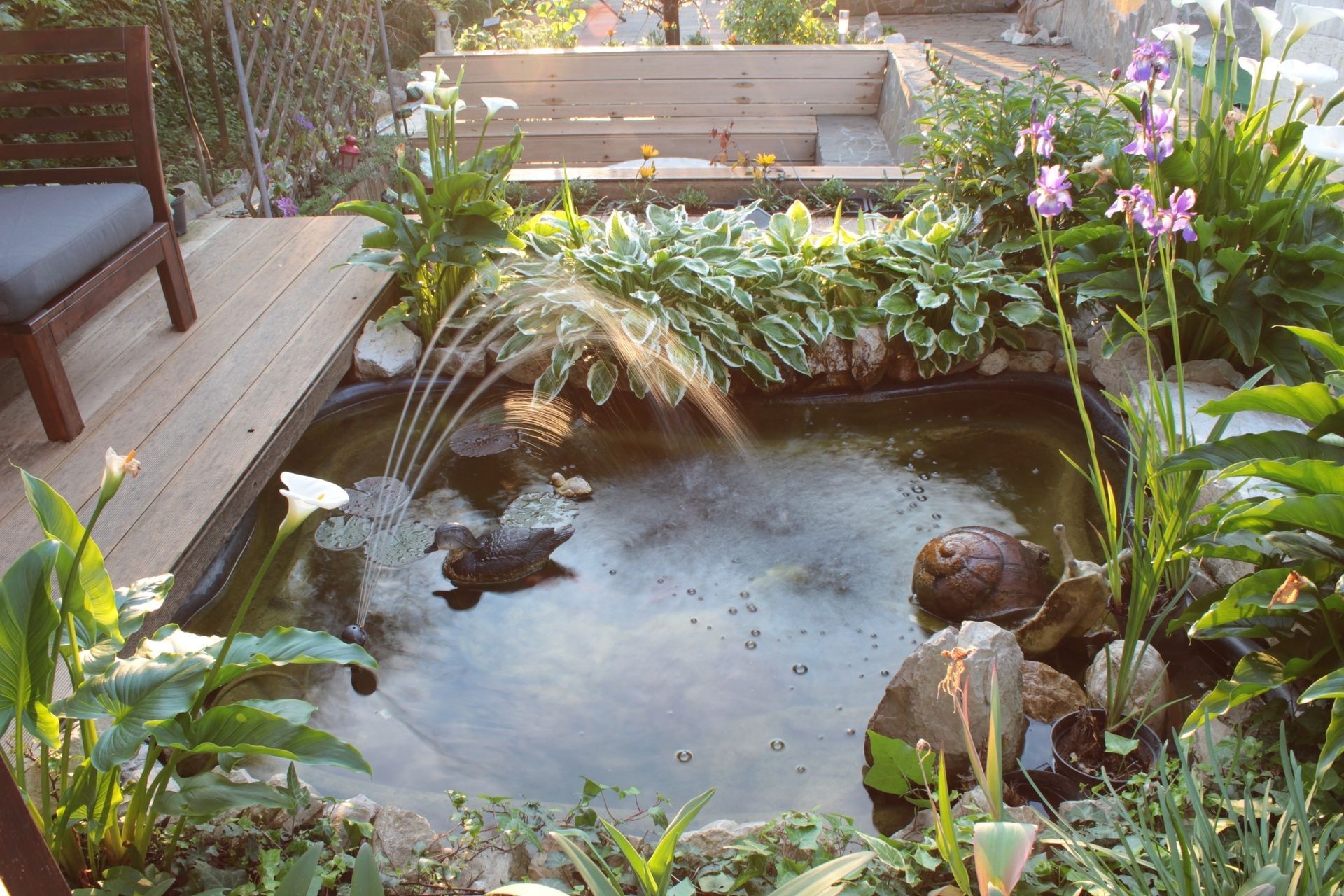 A small pond with a fountain in the middle of it
