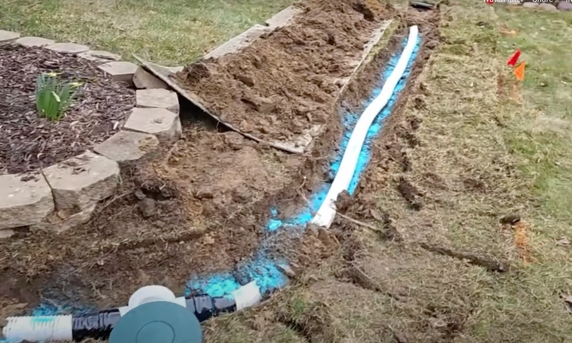 Elite Outdoor Living Solutions installing a residential French drain with pipe and gravel in Gaillardia, OKC.