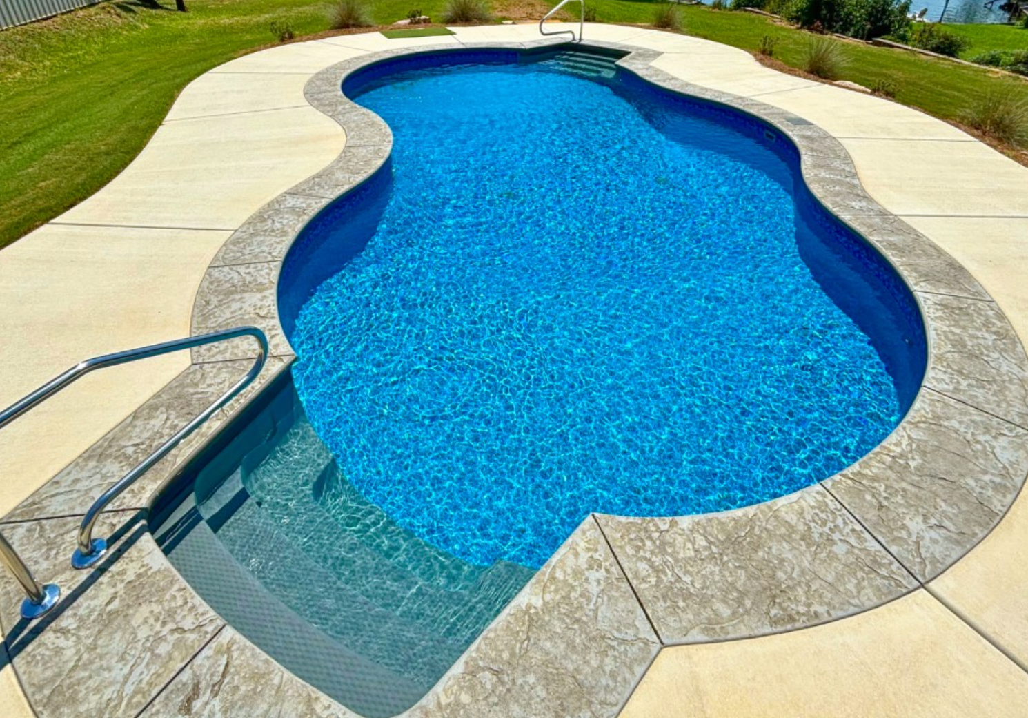 Elite Outdoor Living Solutions is installing a stunning custom swimming pool with concrete pool deck in Oklahoma City.