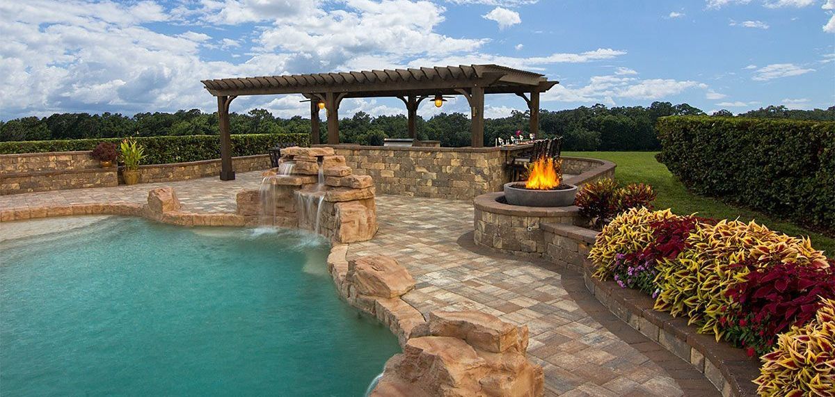 Elite Outdoor Living Solutions is installing a custom pool with a waterfall and fire pit in Oklahoma City.