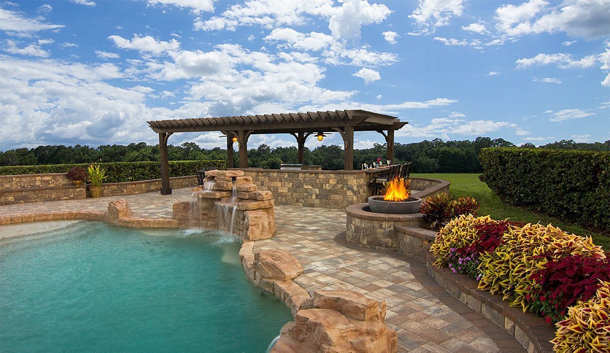 Elite Outdoor Living Solutions is installing a swimming pool with a waterfall and fire pit in Oklahoma City..