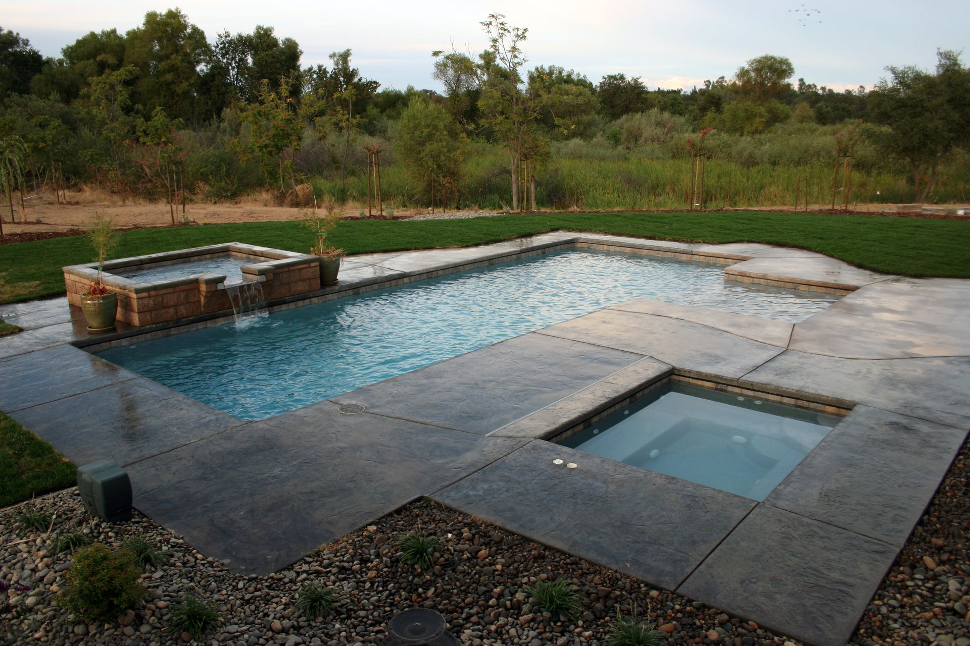 Elite Outdoor Living Solutions is installing a custom swimming pool with a built-in hot tub in Oklahoma City.