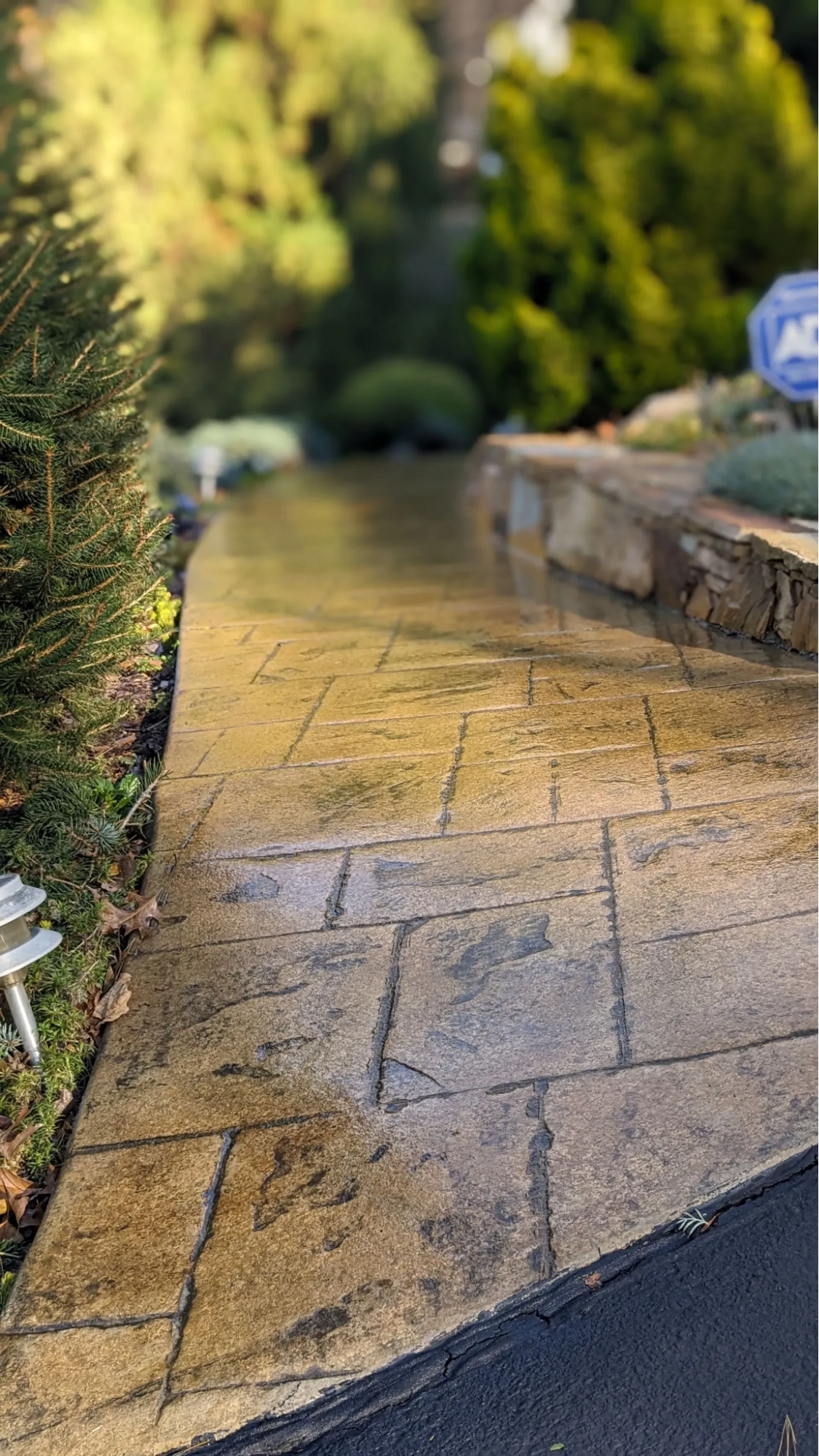 Elite Outdoor Living Solutions installs stamped concrete walkway with warm tones and clean edges in Nichols Hills, Oklahoma.