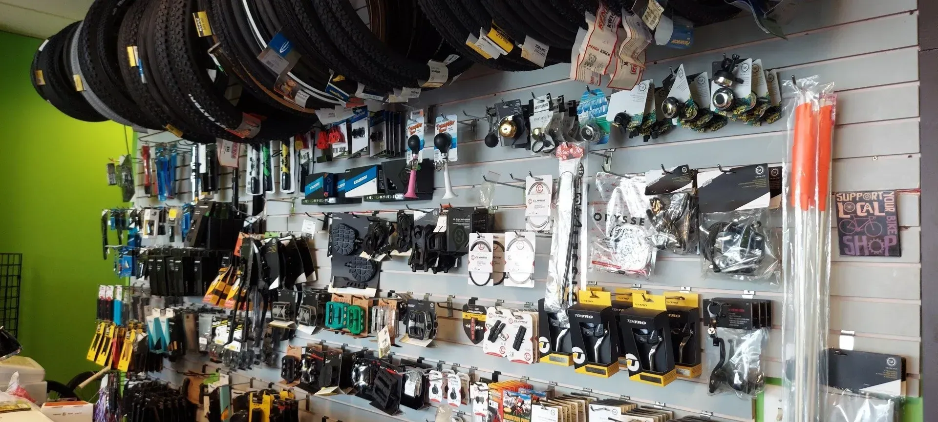 A wall filled with lots of bicycle parts and tires.
