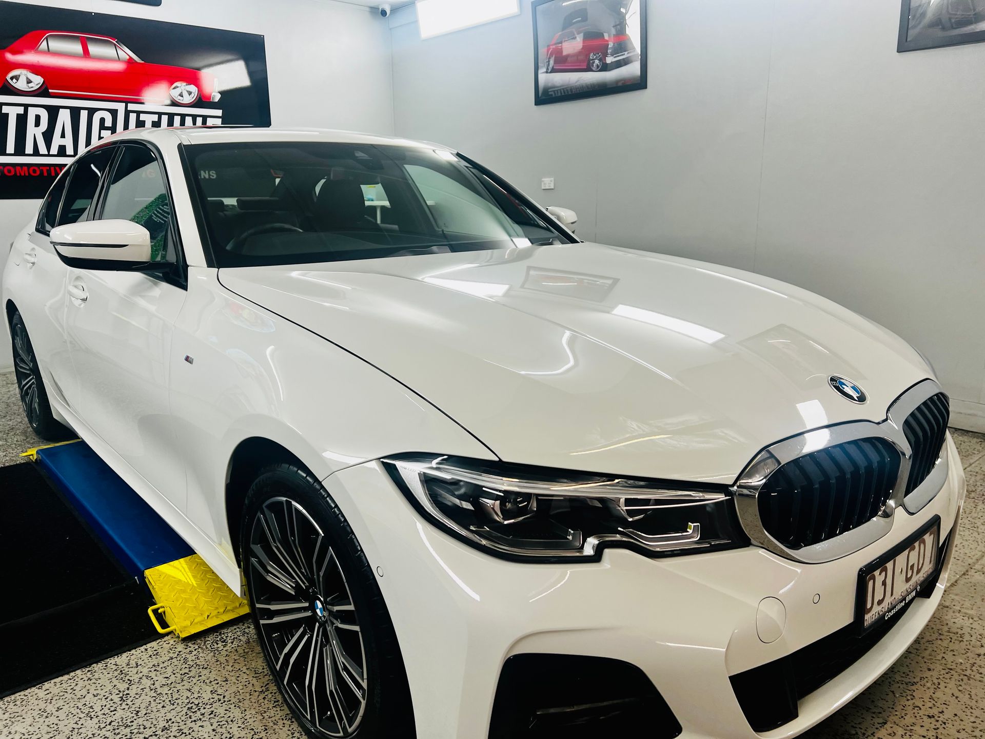 White BMW Sedan Displayed Indoors on A Showroom Floor — Straightline Detailing Cairns in Bungalow, QLD