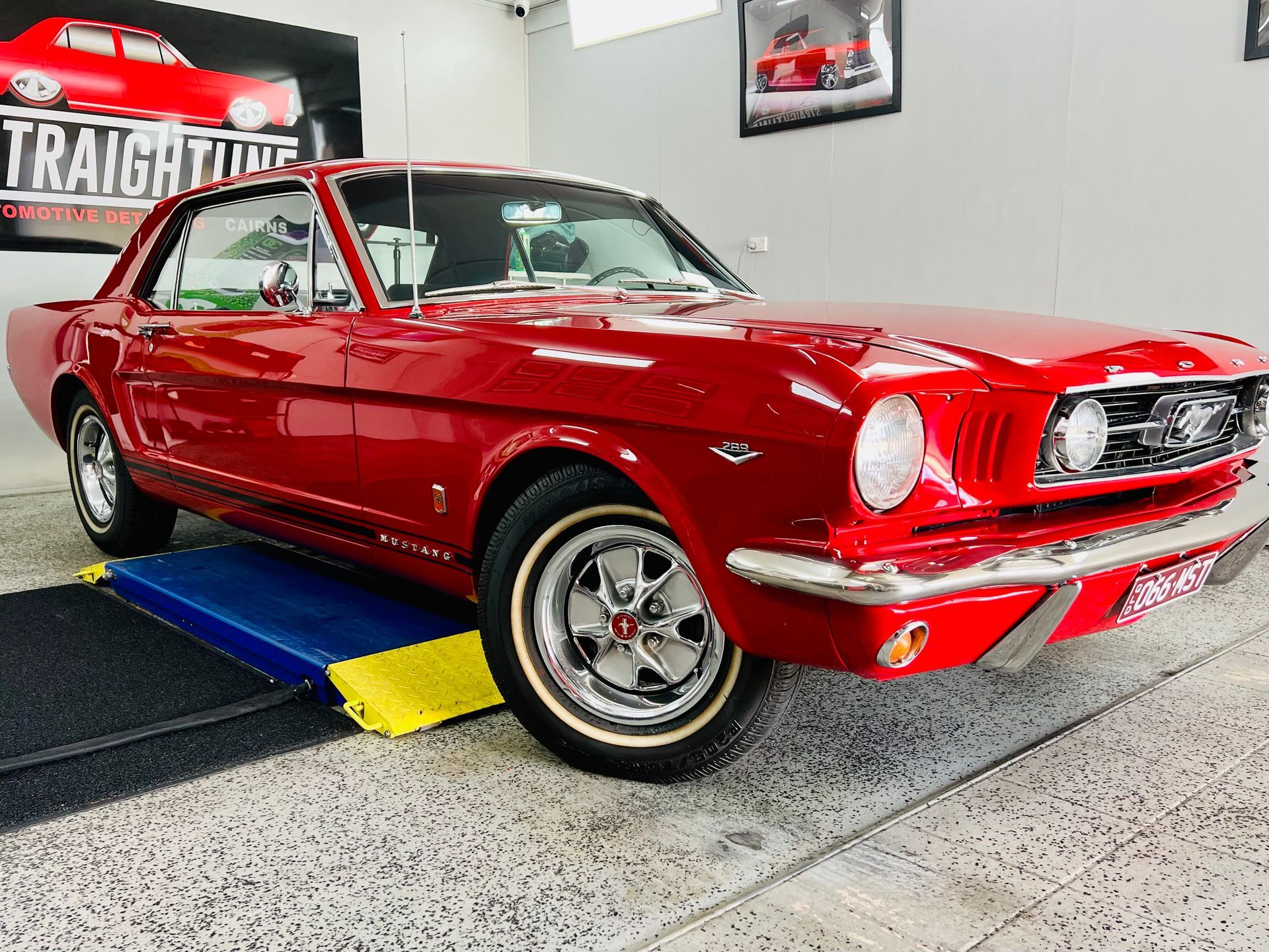 Red Classic Mustang On a Blue and Yellow Display Ramp — Straightline Detailing Cairns in Bungalow, QLD