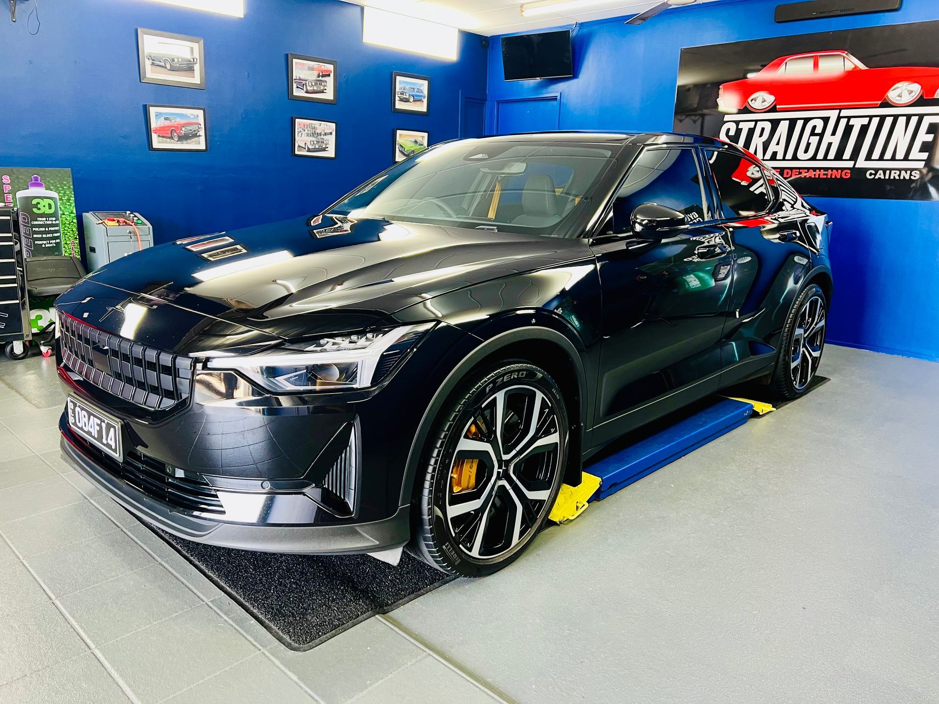 Black Sports Car Displayed in A Blue Showroom — Straightline Detailing Cairns in Bungalow, QLD