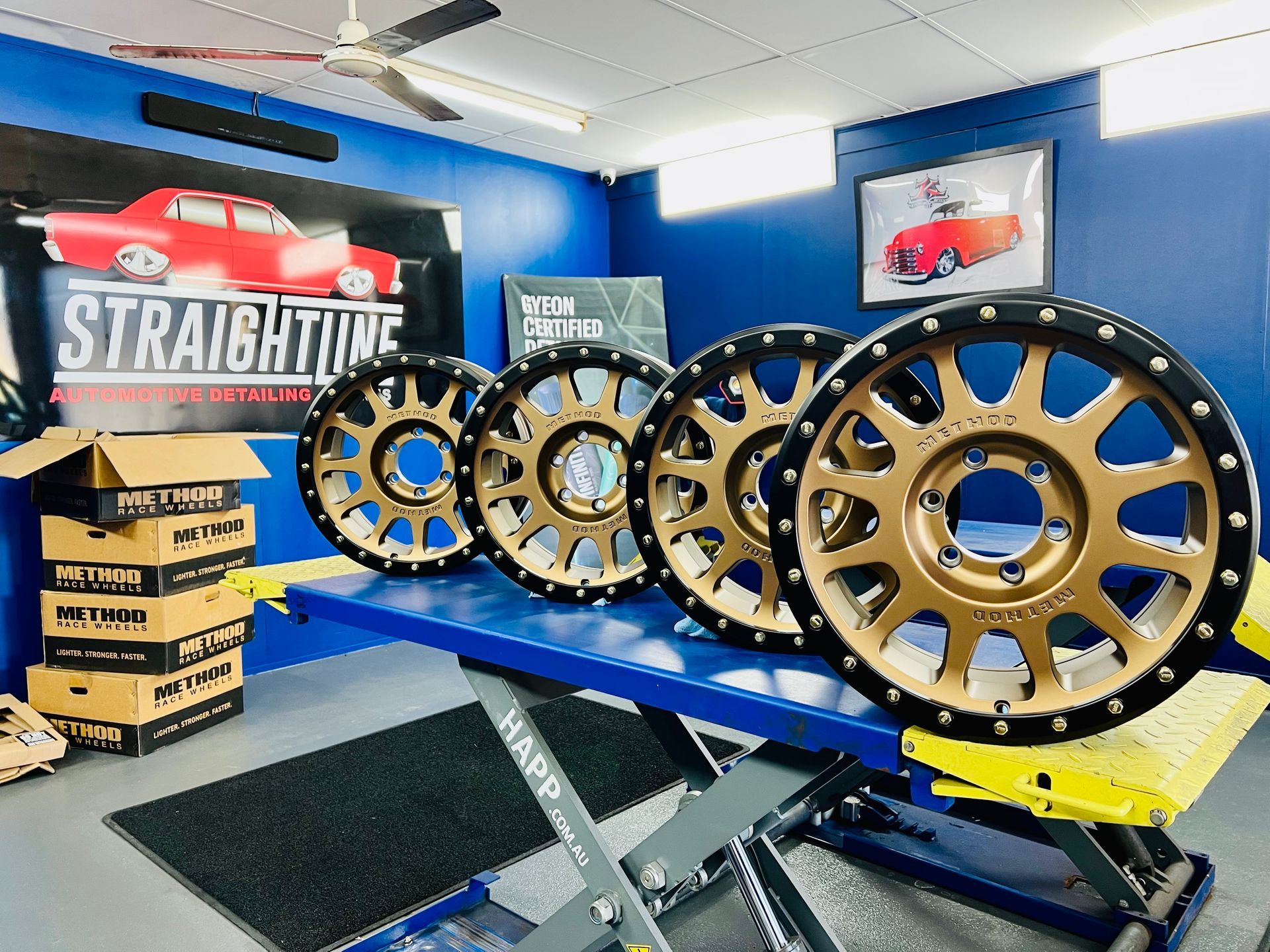 Blue Showroom with Four Gold-And-Black Off-Road Wheel Rims — Straightline Detailing Cairns in Bungalow, QLD