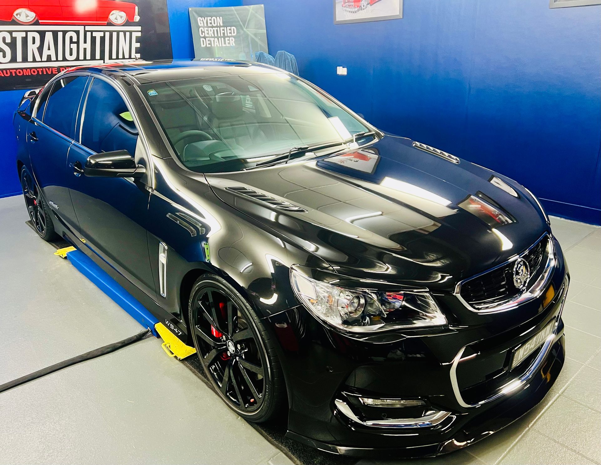 Black Modified Sedan in A Showroom with Blue Walls — Straightline Detailing Cairns in Bungalow, QLD