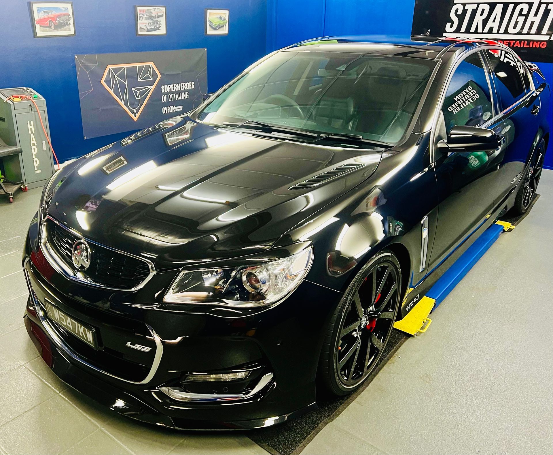 Black Sports Sedan in A Workshop, Shown on A Lift — Straightline Detailing Cairns in Bungalow, QLD