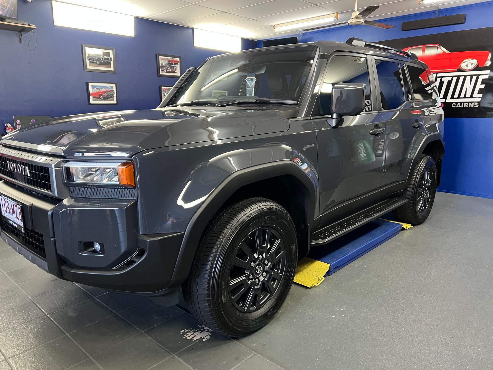 Gray Suv on A Blue Lift Inside an Auto Shop Showroom — Straightline Detailing Cairns in Bungalow, QLD