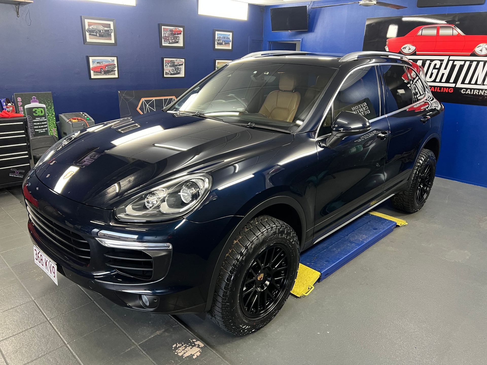 Black SUV In an Auto Shop with Blue Walls and Framed Car Photos — Straightline Detailing Cairns in Bungalow, QLD