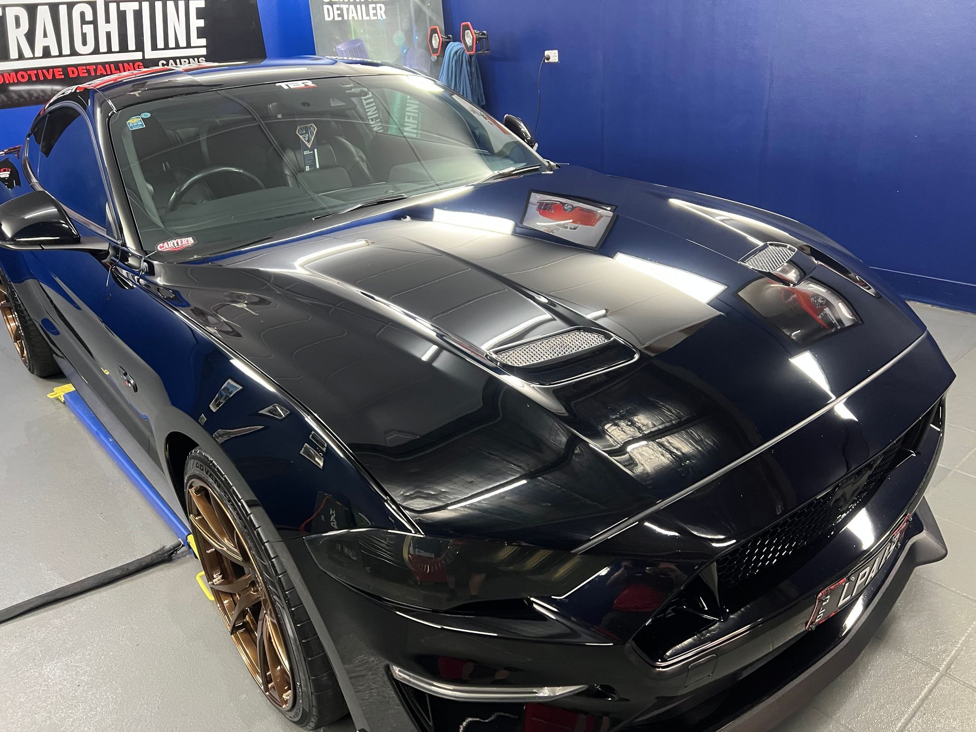 Black Sports Car on Display at An Indoor Auto Show — Straightline Detailing Cairns in Bungalow, QLD