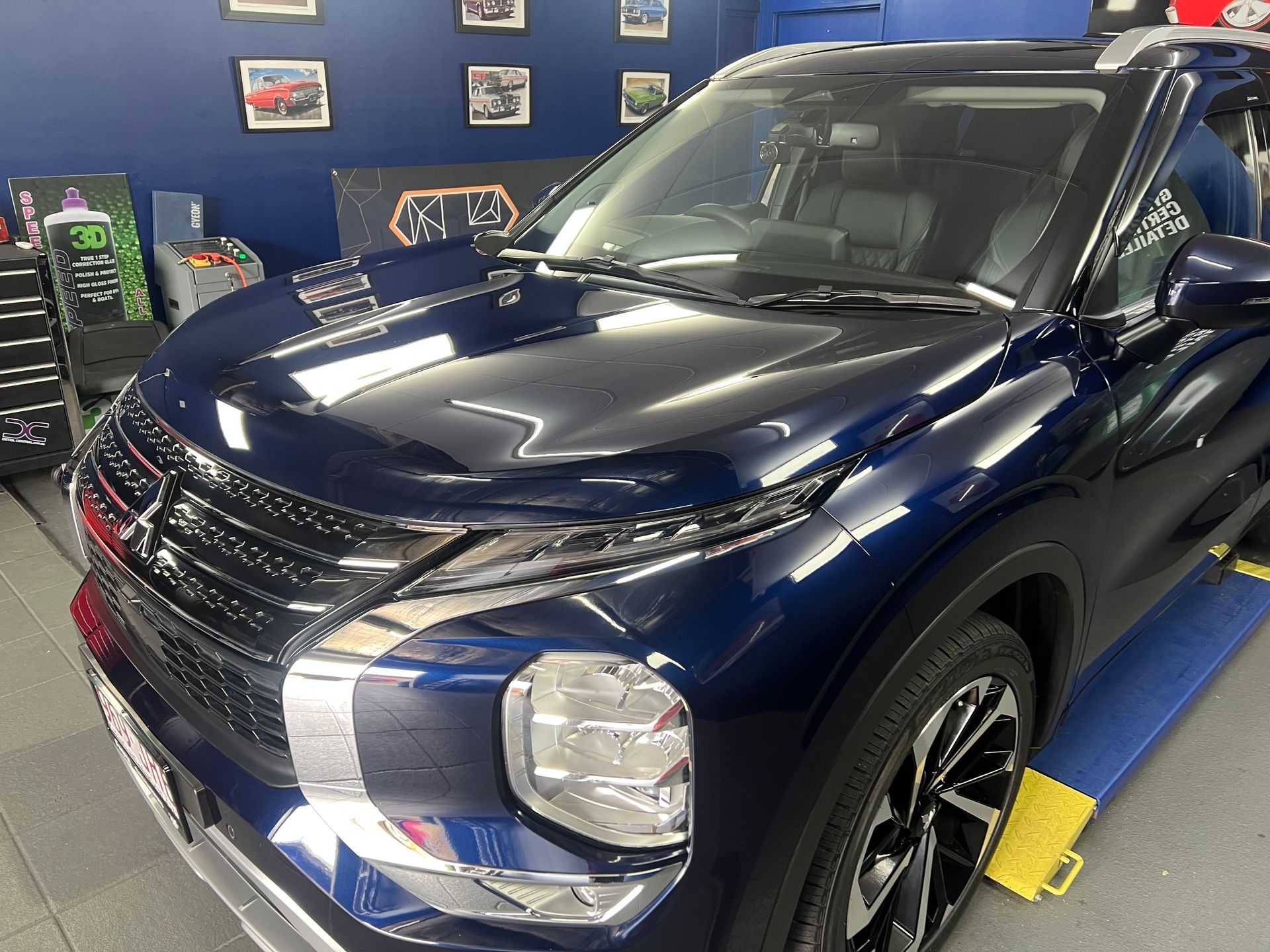 Dark Blue SUV In an Auto Shop, Front-Left View on A Lift — Straightline Detailing Cairns in Bungalow, QLD