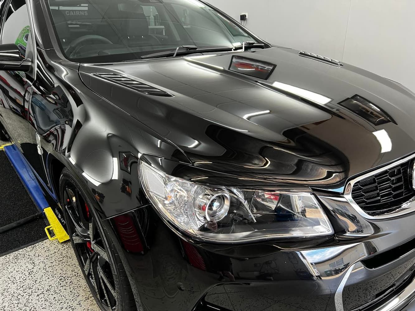 A Black Car is Parked in a Garage — Straightline Detailing Cairns in Bungalow, QLD