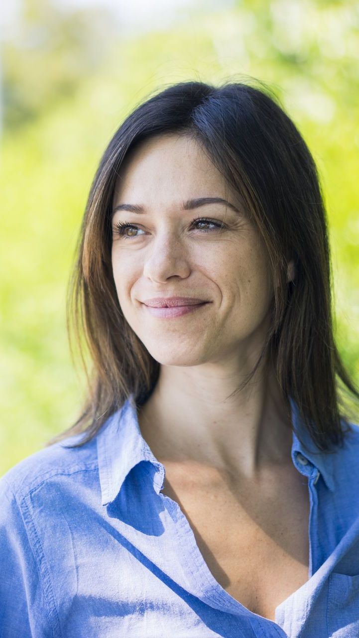 A woman wearing a blue shirt is smiling for the camera after therapy with Erin Freeman