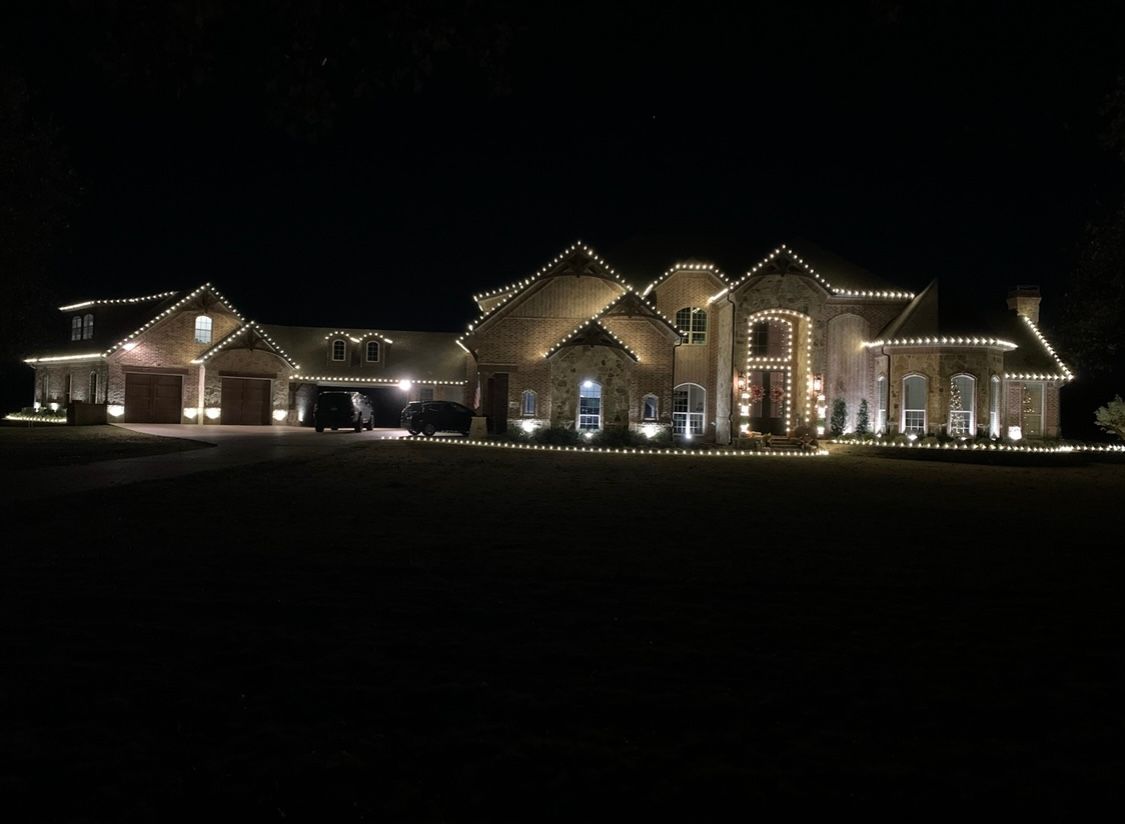 large brick house with white christmas lights