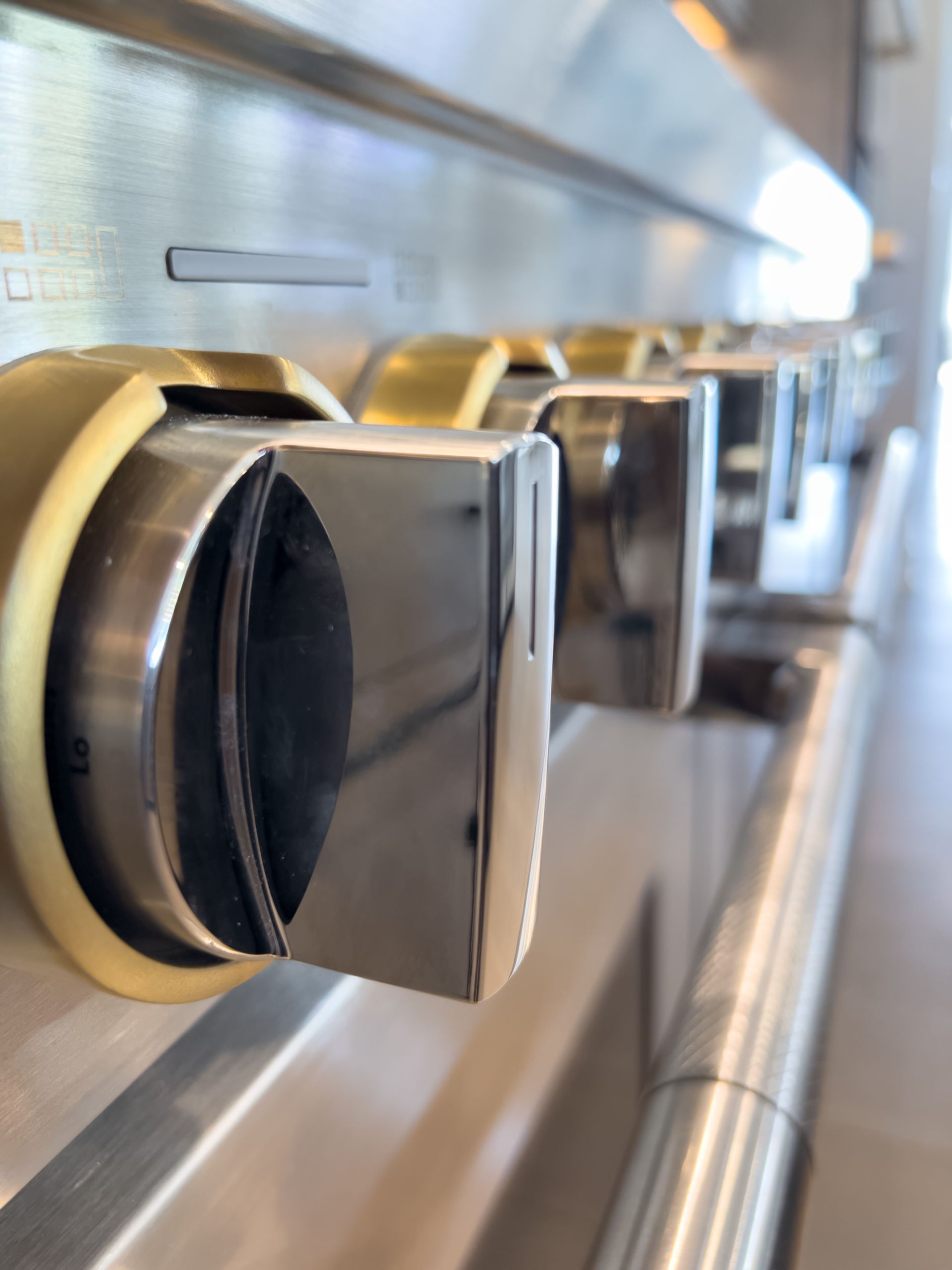 Close-up of stainless steel oven knobs on a kitchen range