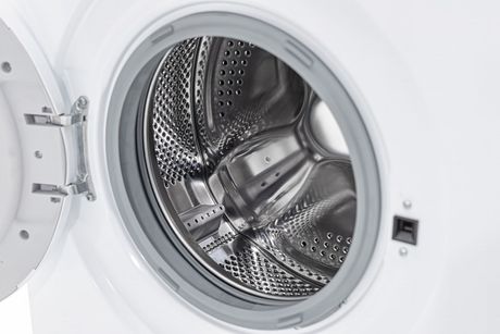 Open front-loading washing machine drum with stainless steel interior and white door frame