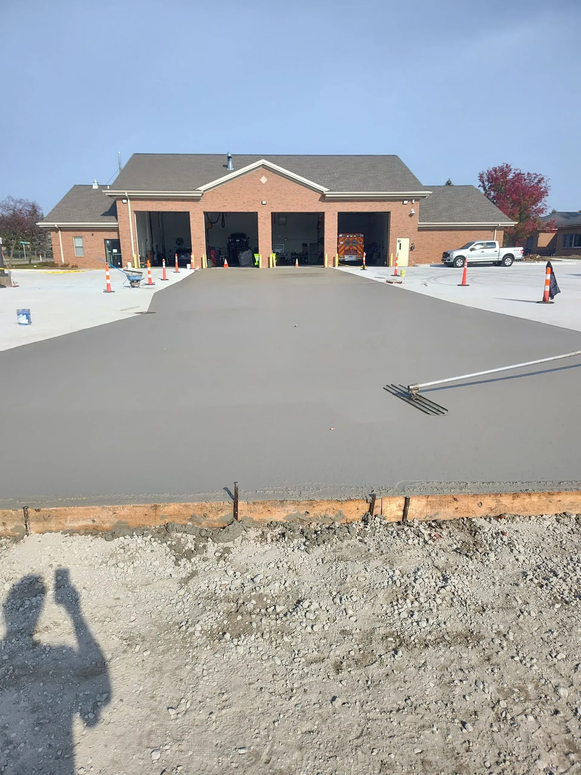 New brick building with covered entrance and cones, viewed from a paved parking lot. New brick building with covered entrance and cones, viewed from a paved parking lot.