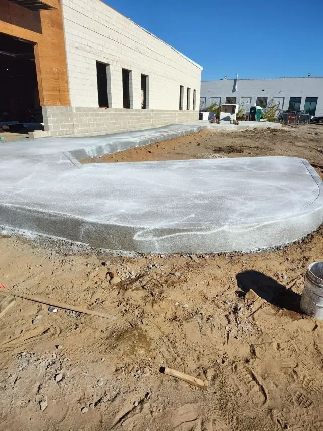 Large white tarp-covered mound on a dirt lot beside a building under construction Large white tarp-covered mound on a dirt lot beside a building under construction