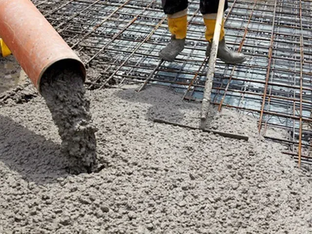 Concrete being poured onto steel rebar at a construction site. Concrete being poured onto steel rebar at a construction site.