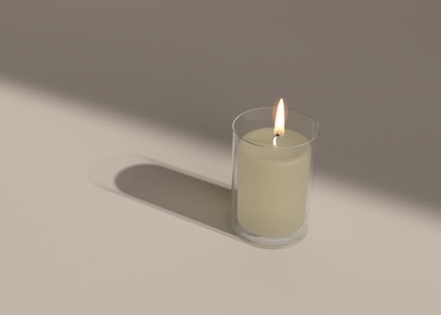 Single lit candle in glass holder casting soft shadow, cremation services Tupelo, MS