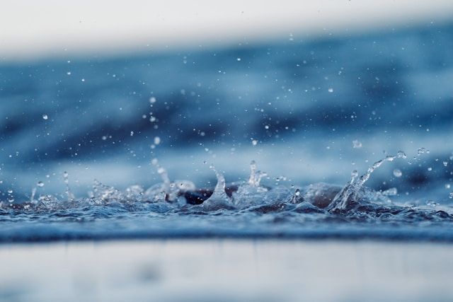 Water droplets splashing on surface with soft blue tones, symbolizing reflection, funeral homes Saltillo, MS