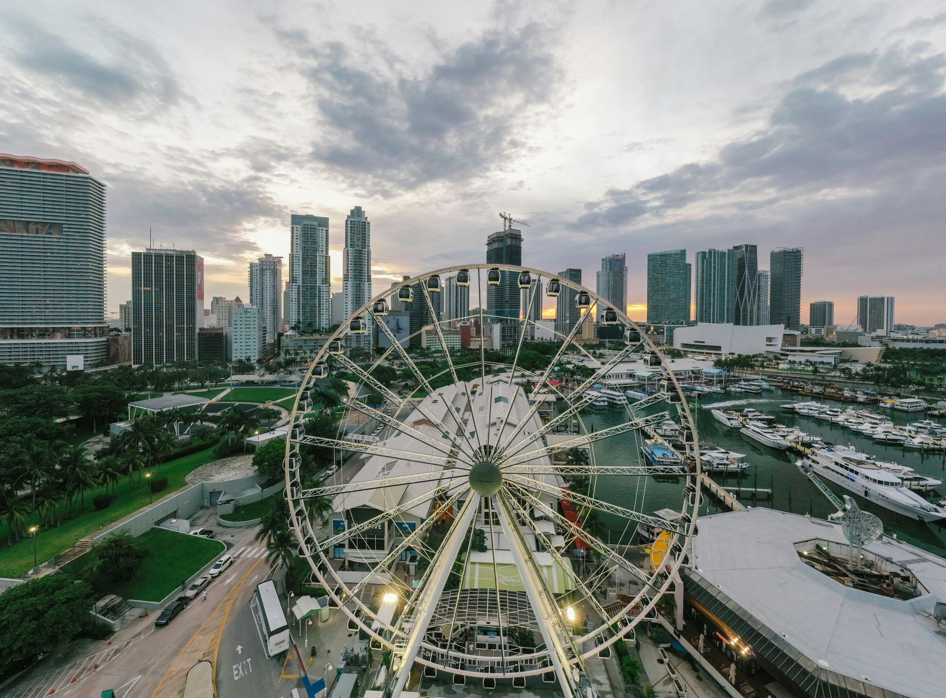 An aerial view of a ferris wheel in front of a city skyline.
