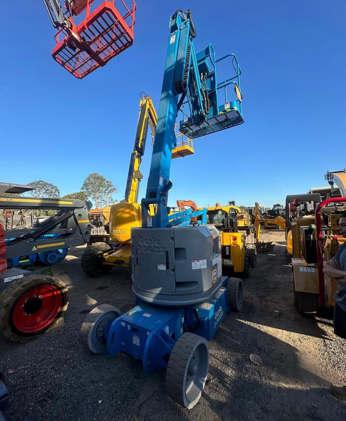 Blue aerial lift in a construction equipment yard.