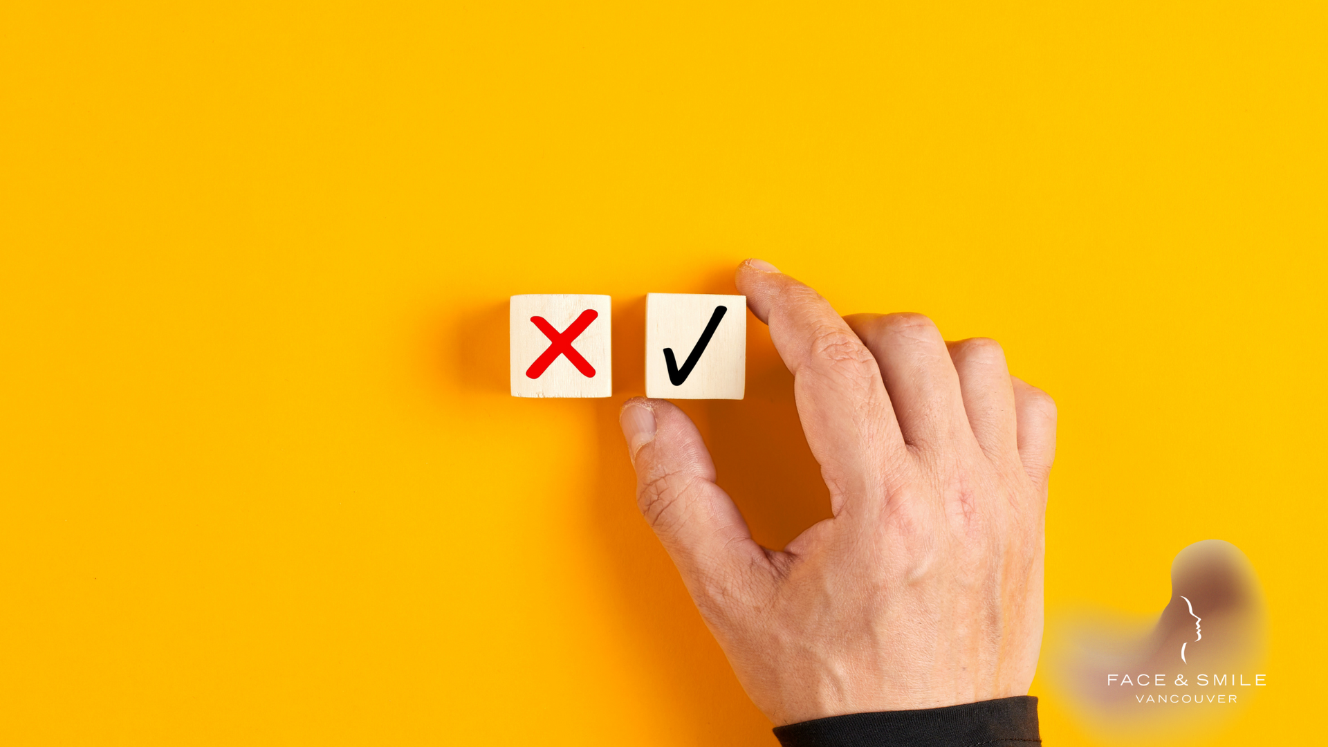 Hand placing a checkmark block beside a red X block on a yellow background