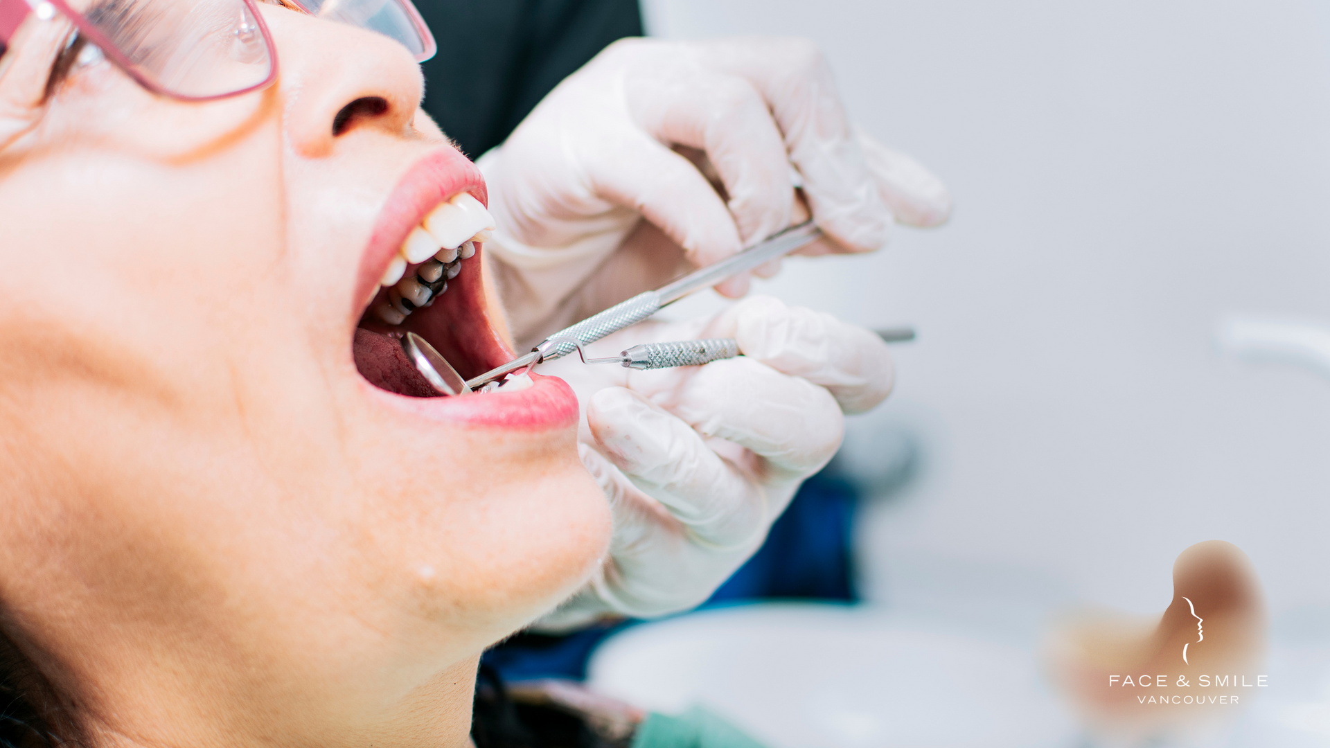 A woman is getting her teeth examined by a dentist.