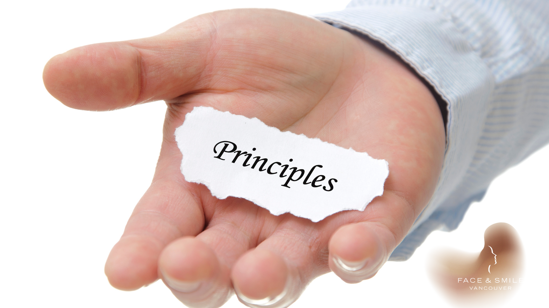 Hand holding torn paper labeled “Principles” on a white background