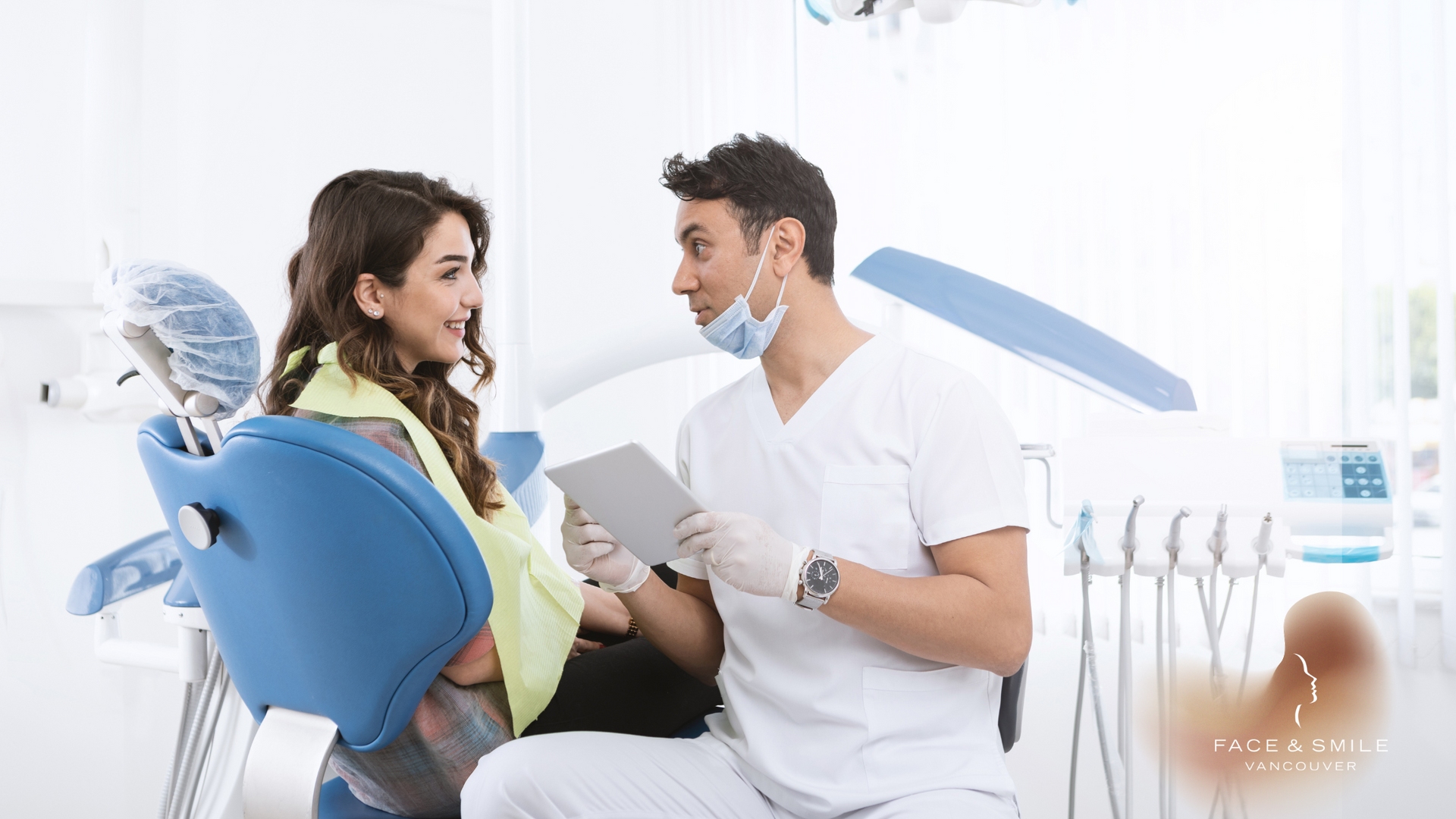 A dentist is talking to a patient in a dental chair.