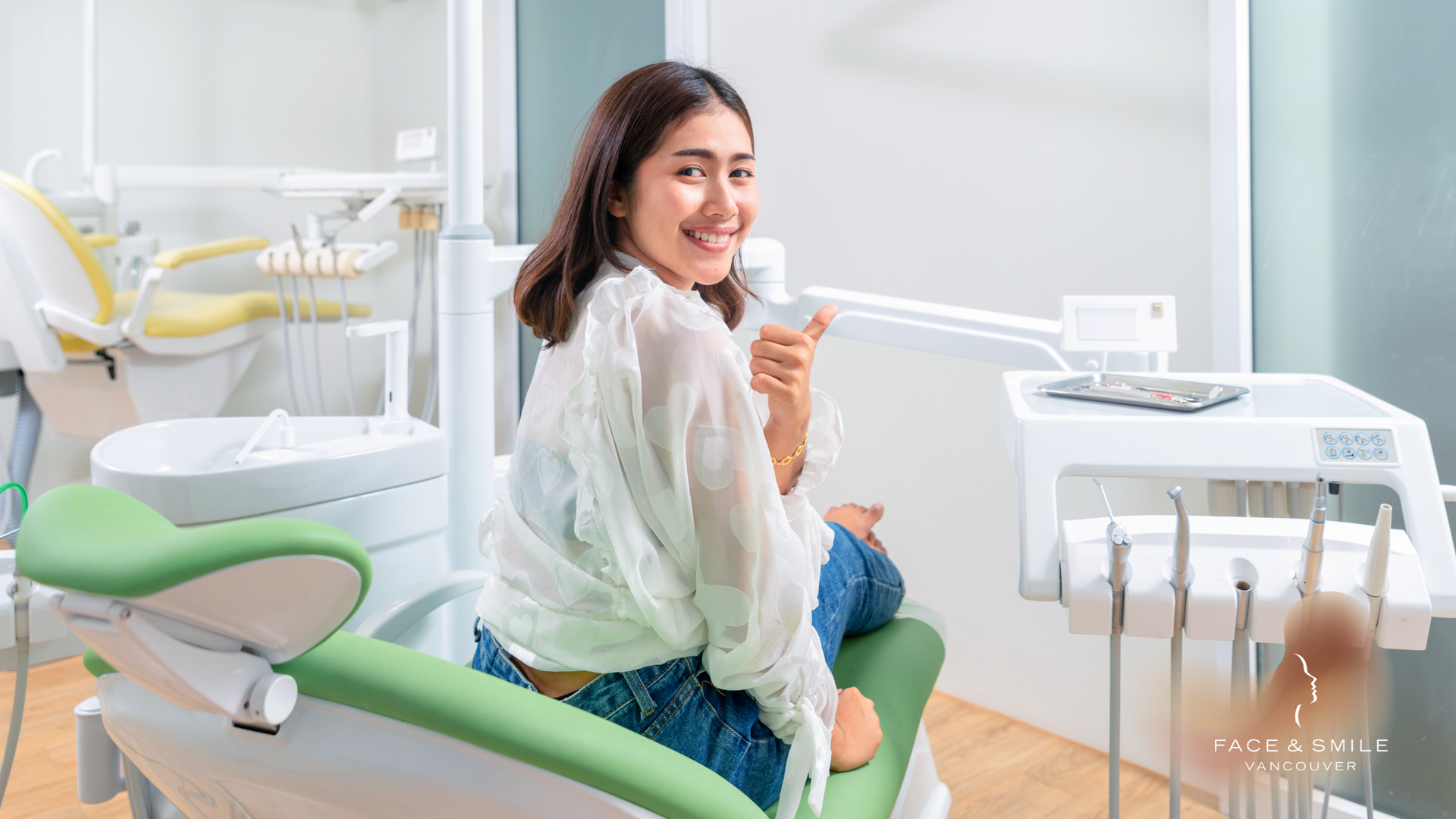 A woman is sitting in a dental chair and smiling.