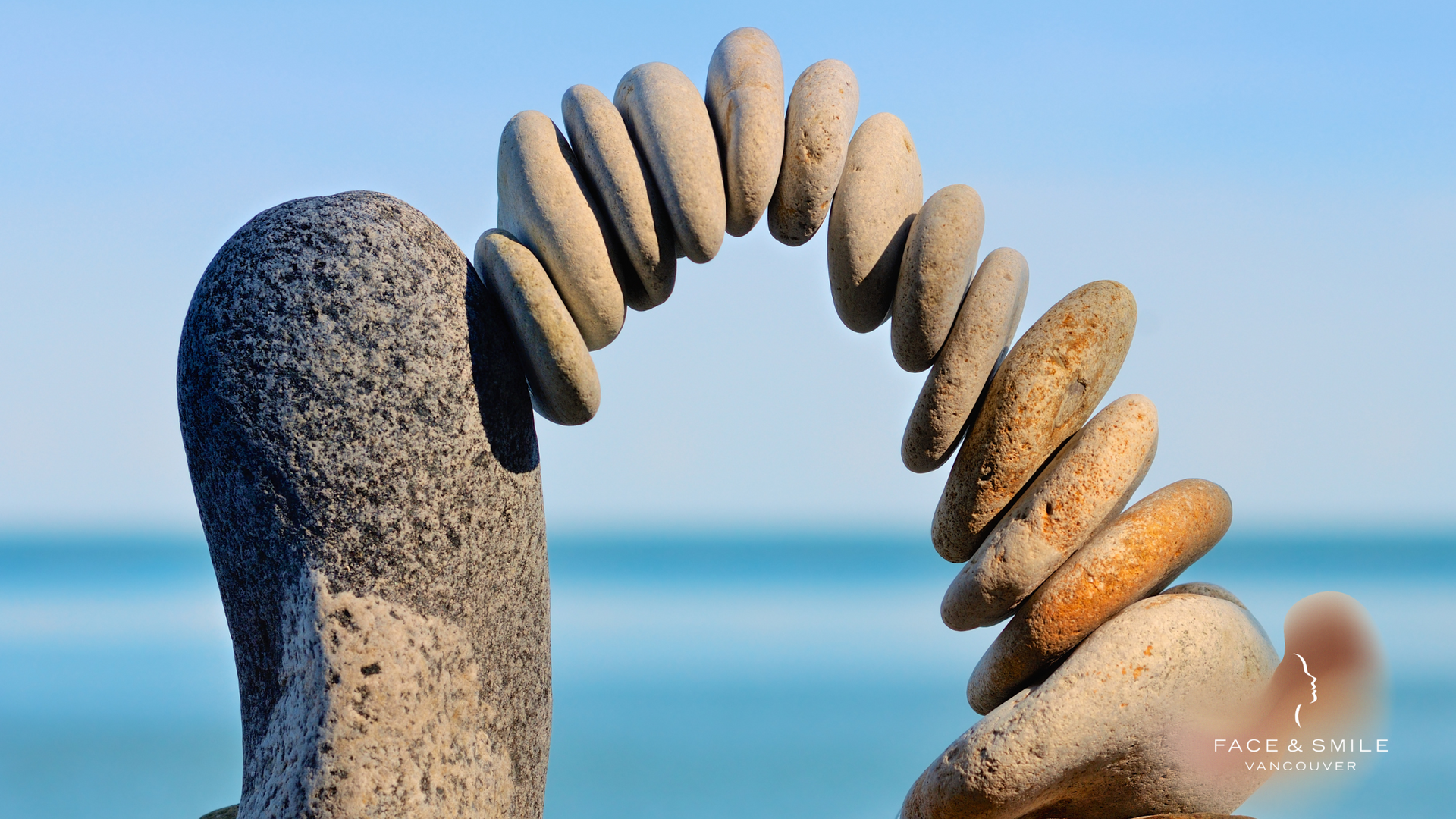 Stacked stones forming an arch on a beach with the ocean in the background