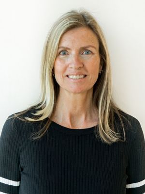A woman in a black sweater is smiling for the camera.