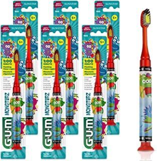 A bunch of gum monsterz toothbrushes are sitting next to each other on a table.