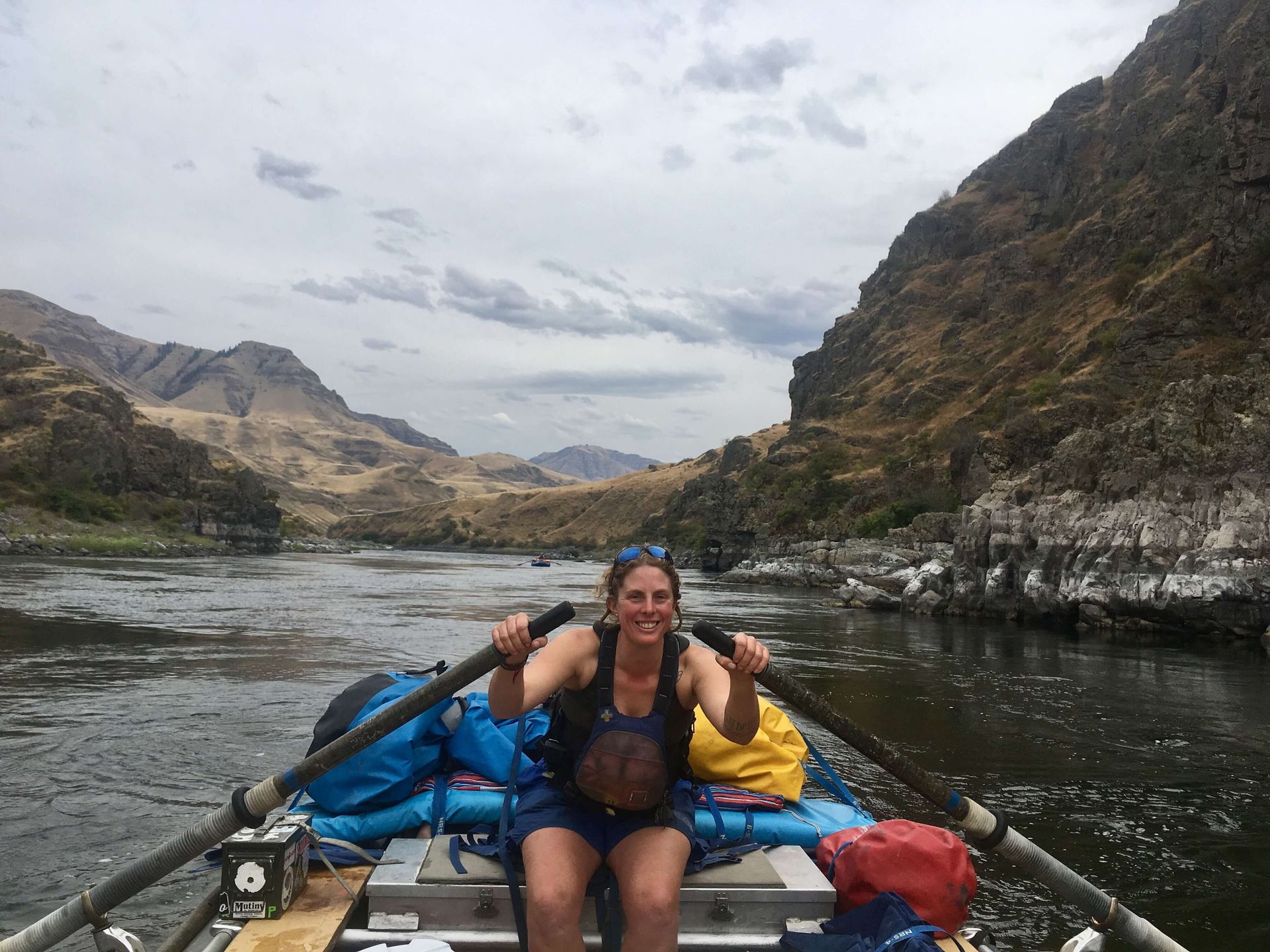 Woman Sitting in A Raft on A River with Mountains in Background