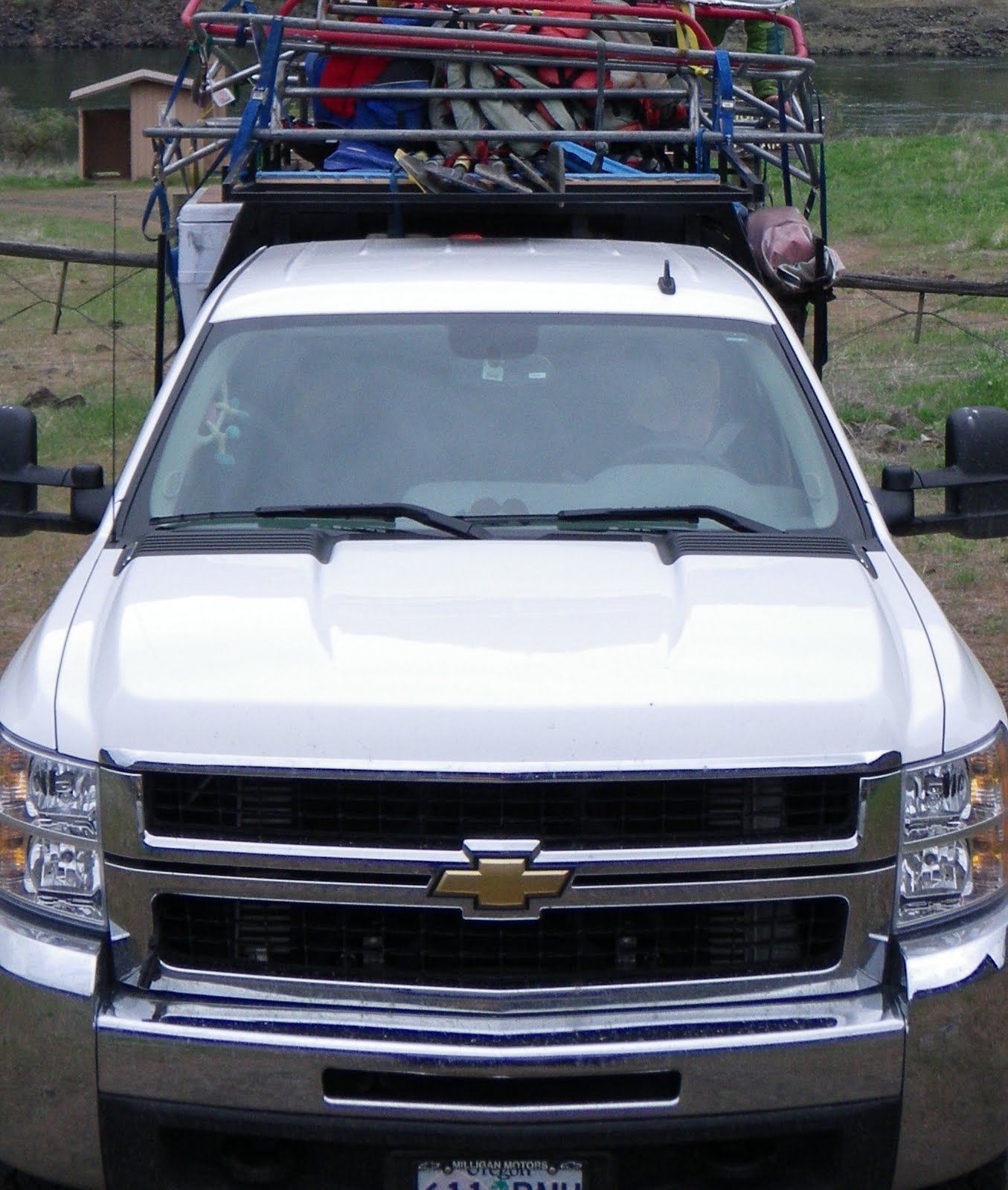 A white chevrolet truck with a trailer attached to it