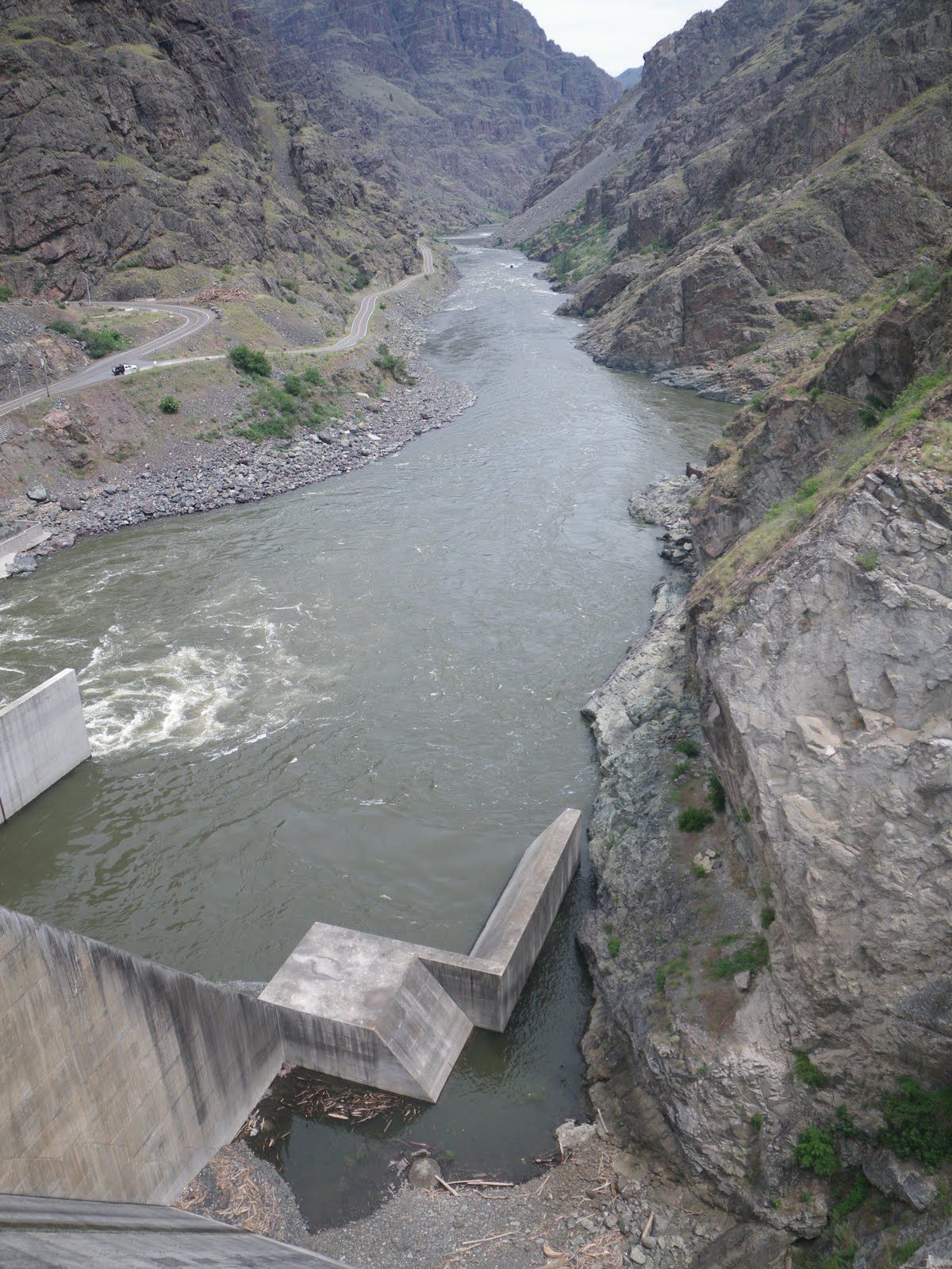 A river flowing through a canyon with mountains in the background