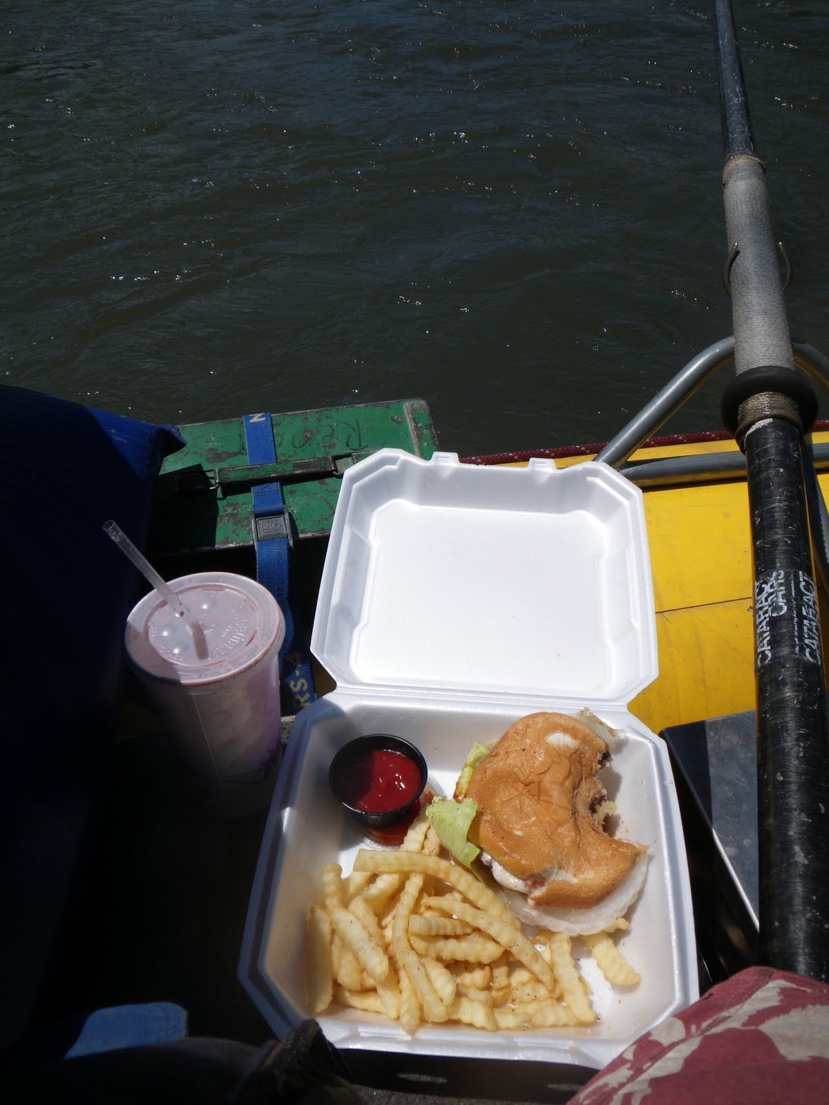 A styrofoam container contains a hamburger and french fries